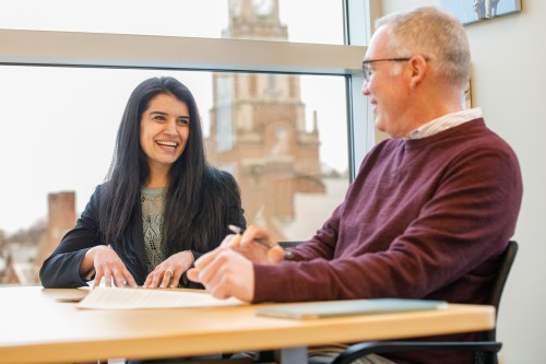 Two people talking in conference room